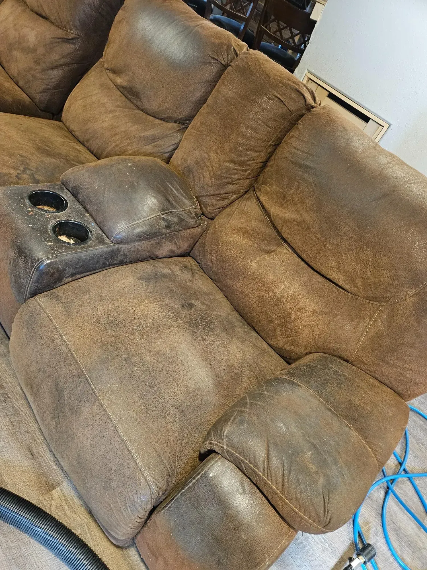 A brown leather recliner is sitting on a carpet in a living room.