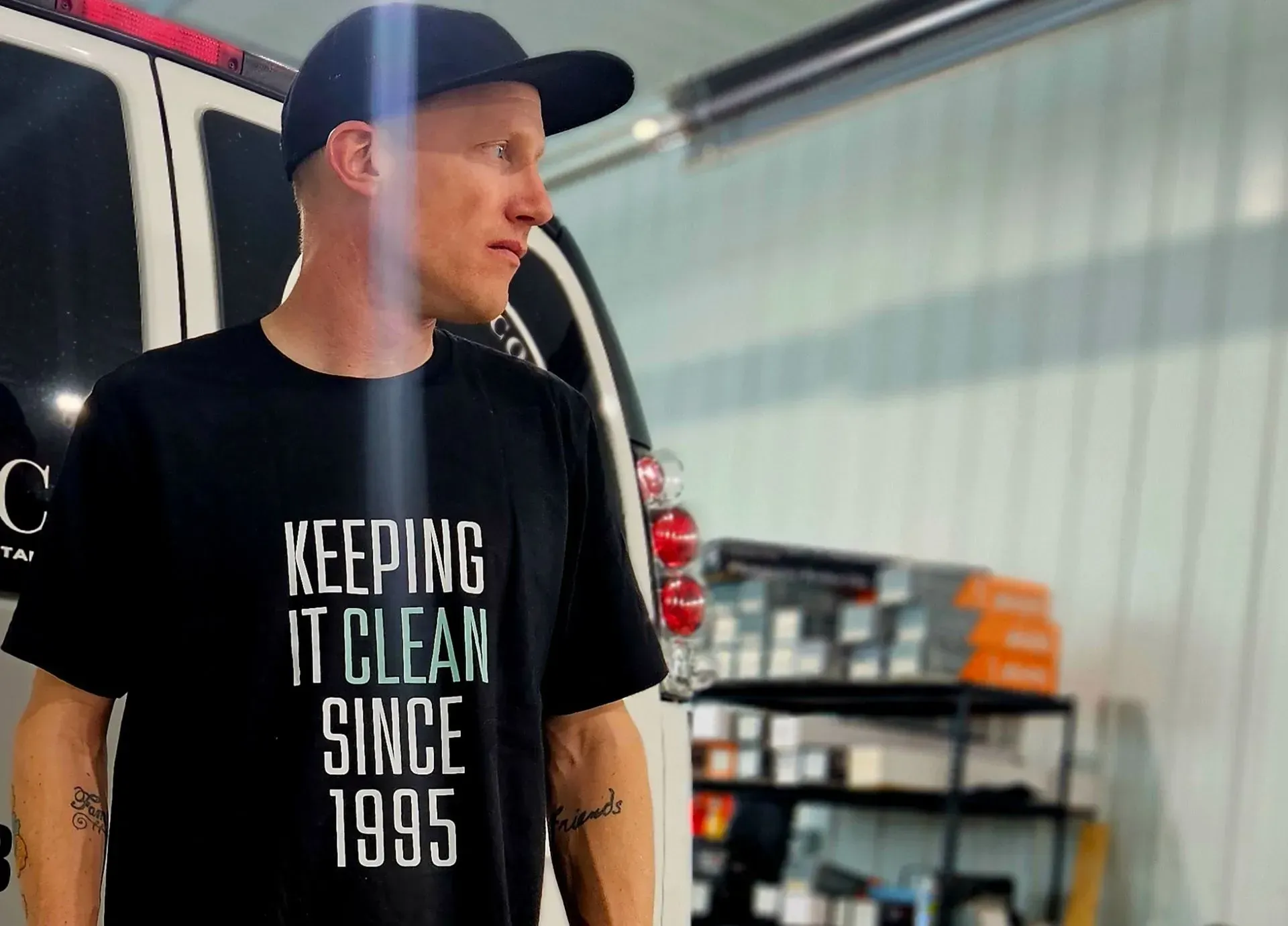 A man wearing a black t-shirt that says keeping it clean since 1995