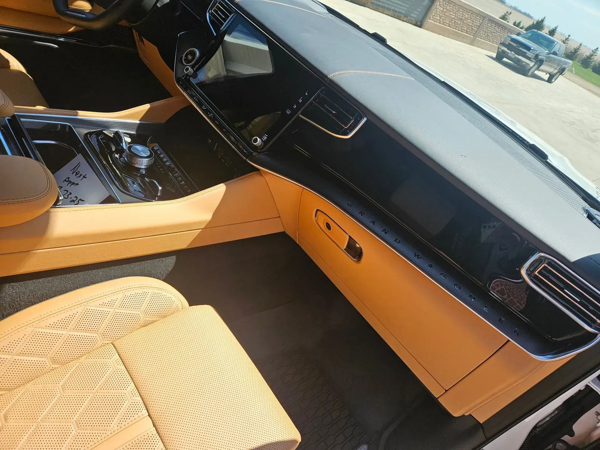 The interior of a car with a black dashboard and tan seats