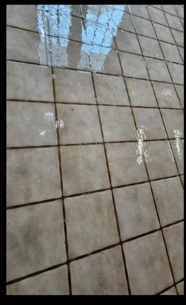 A tiled floor with a reflection of a building
