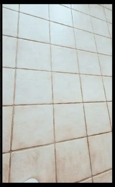 A tiled floor with a white shoe on it