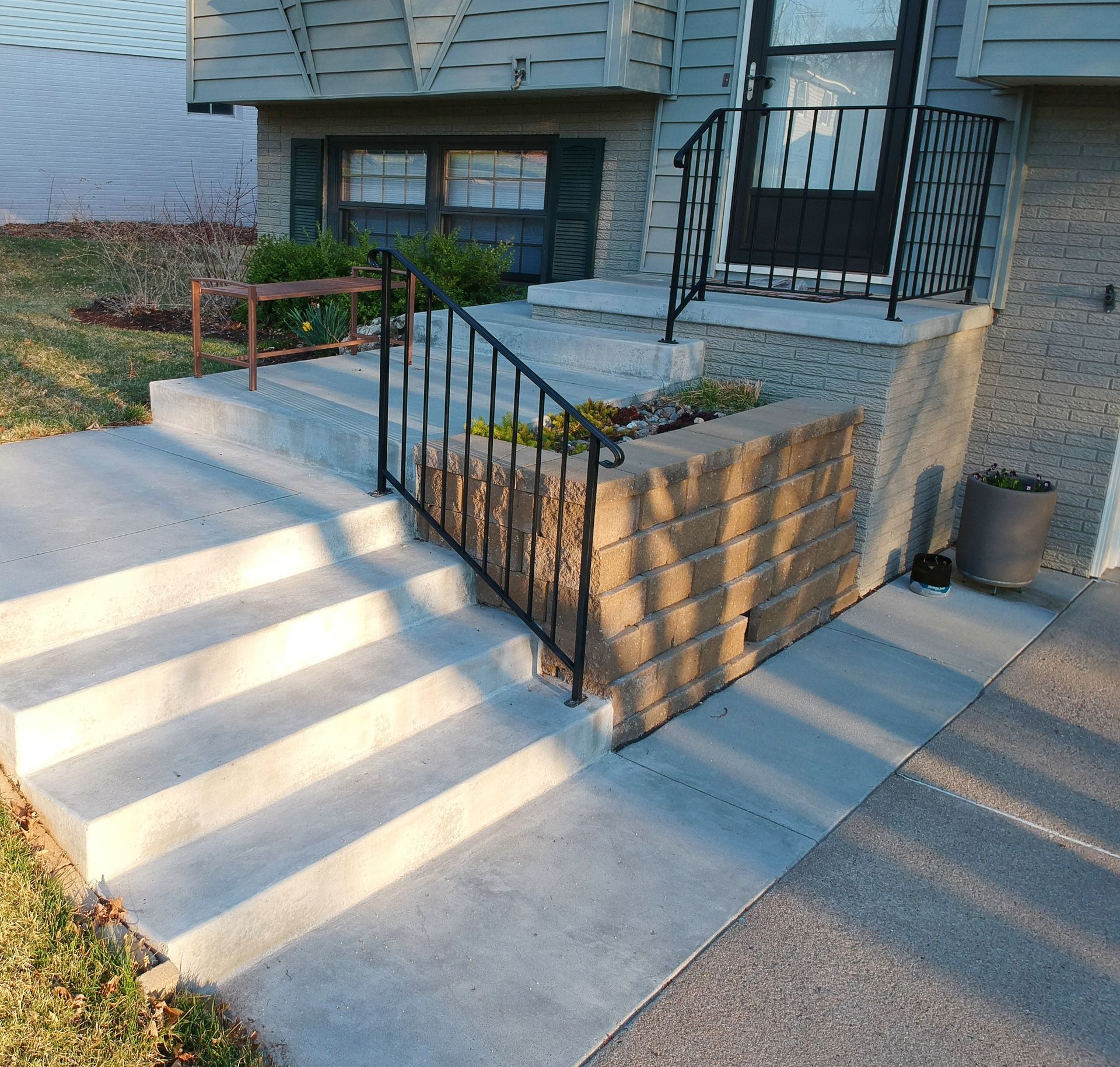 Un escalier menant à une maison avec une rampe en fer forgé