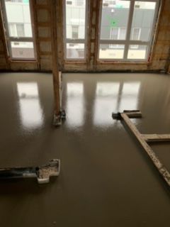 Une pièce avec beaucoup de fenêtres et un sol en béton.