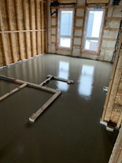 Une pièce avec un sol en béton et beaucoup de fenêtres.