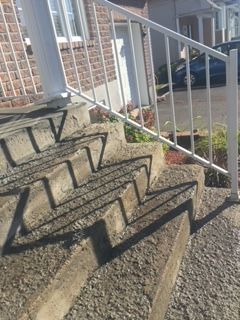 Un ensemble d'escaliers menant à une maison avec une rampe en métal.