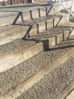 L'ombre d'un escalier se projette sur le sol.