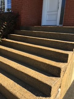 Un ensemble de marches en béton menant à un bâtiment en briques.