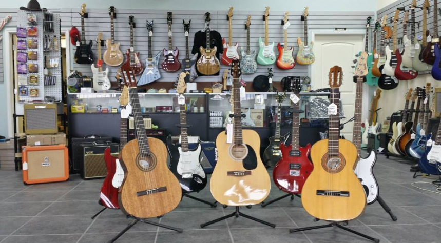 A bunch of guitars are lined up in a store