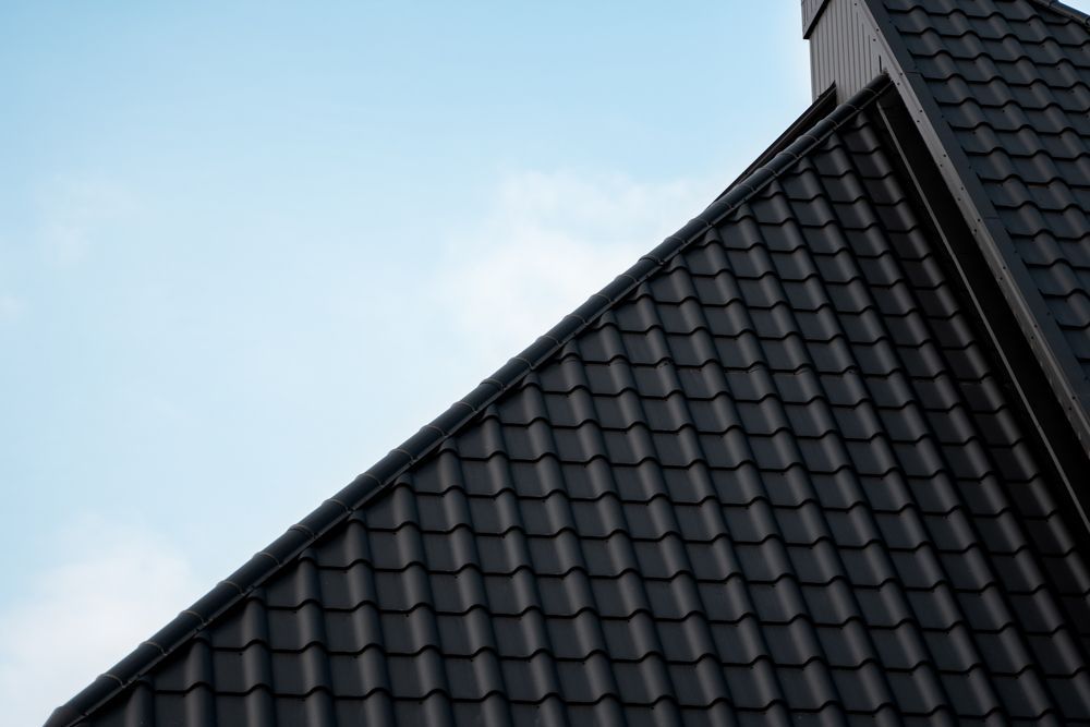 A Close Up of a Black Roof With a Blue Sky in the Background — Apex Roofing Group in Lismore, NSW