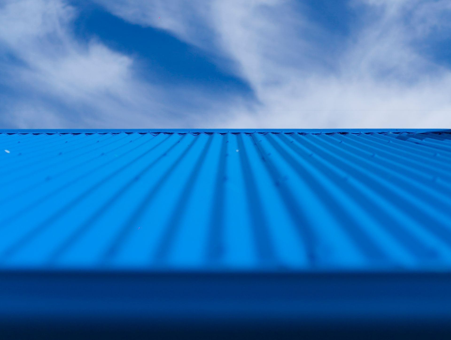 A Blue Roof With a Blue Sky in the Background — Apex Roofing Group in Maclean, NSW