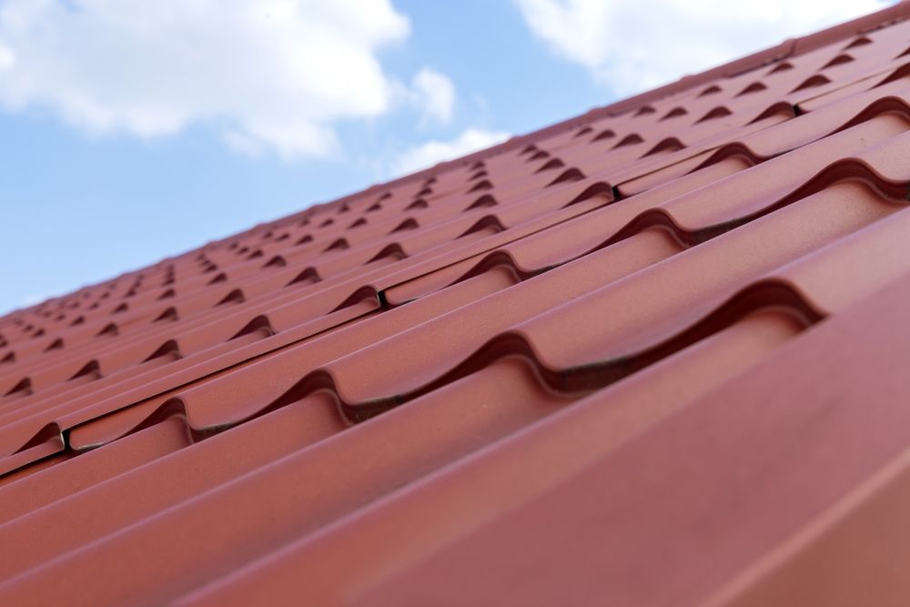 A Close Up of a Red Roof With Snow Stoppers on It — Apex Roofing Group in Kingscliff, NSW