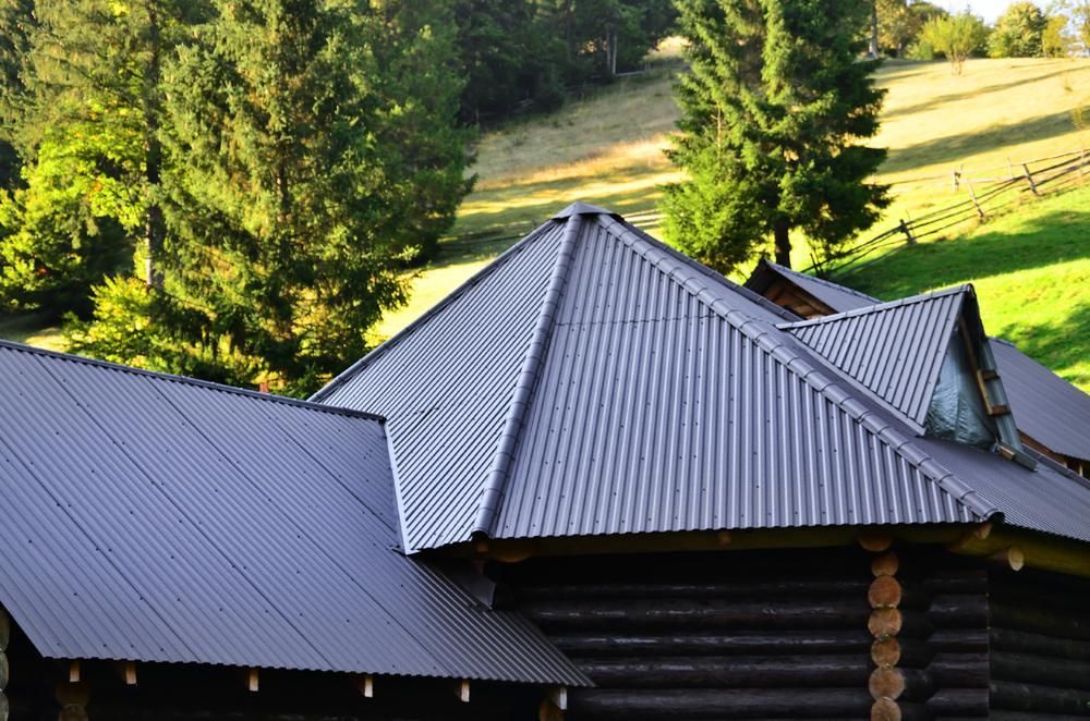 A Log Cabin with A Corrugated Metal Roof — Apex Roofing Group in Pottsville, NSW