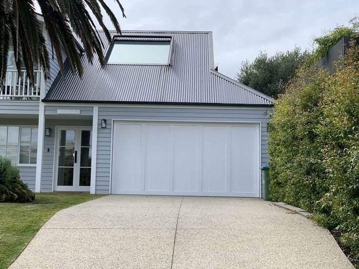 A White Building With a Metal Roof and Windows — Apex Roofing Group in Byron Bay, NSW