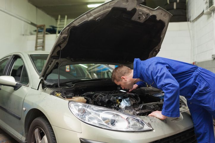 A person looking at the hood of a car | Auto Repair in Greenfield Wi | Dave's Garage Inc ] 