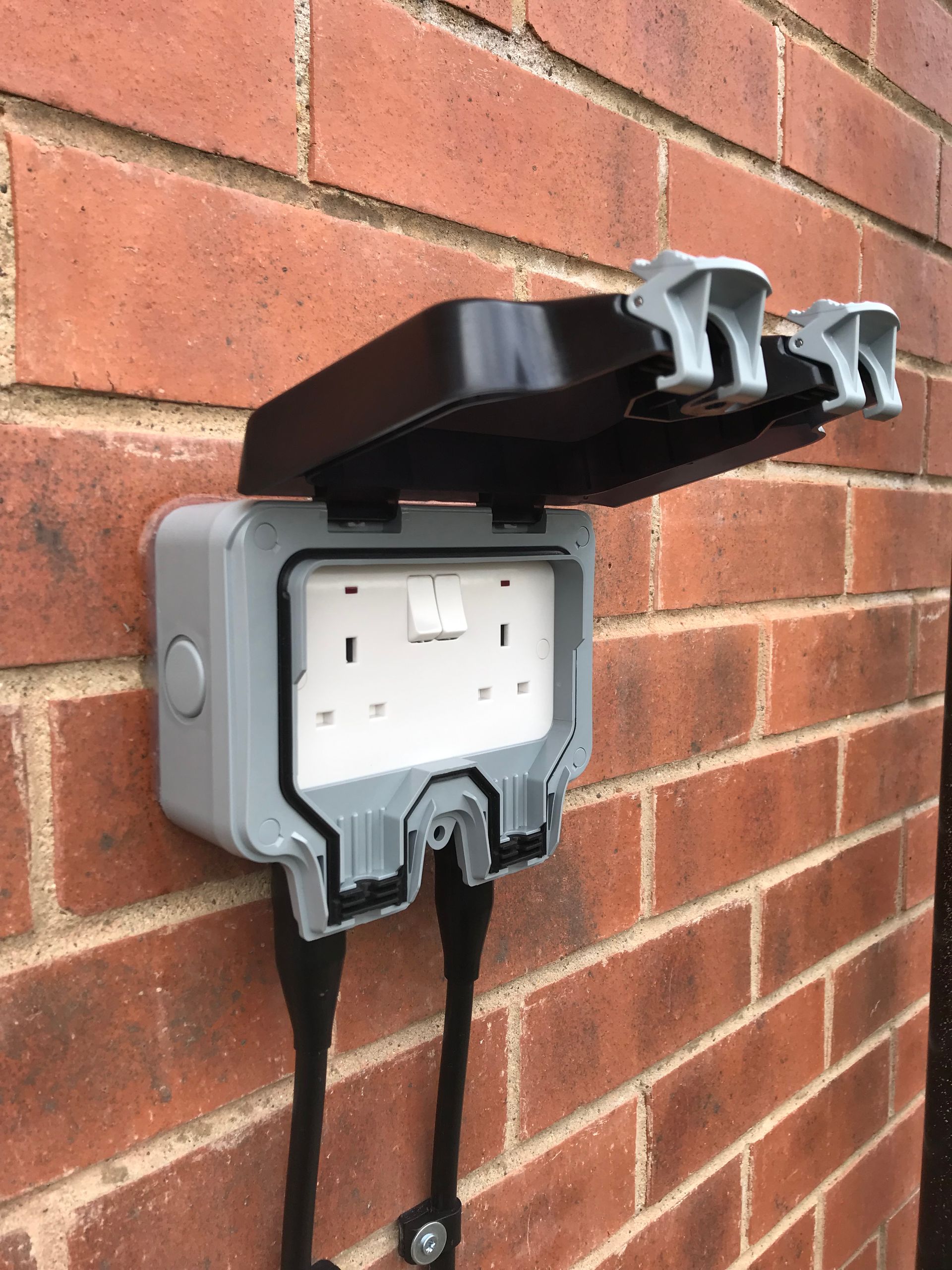 Outdoor electric socket installed on a garden wall by AJOB Electrical Ltd.