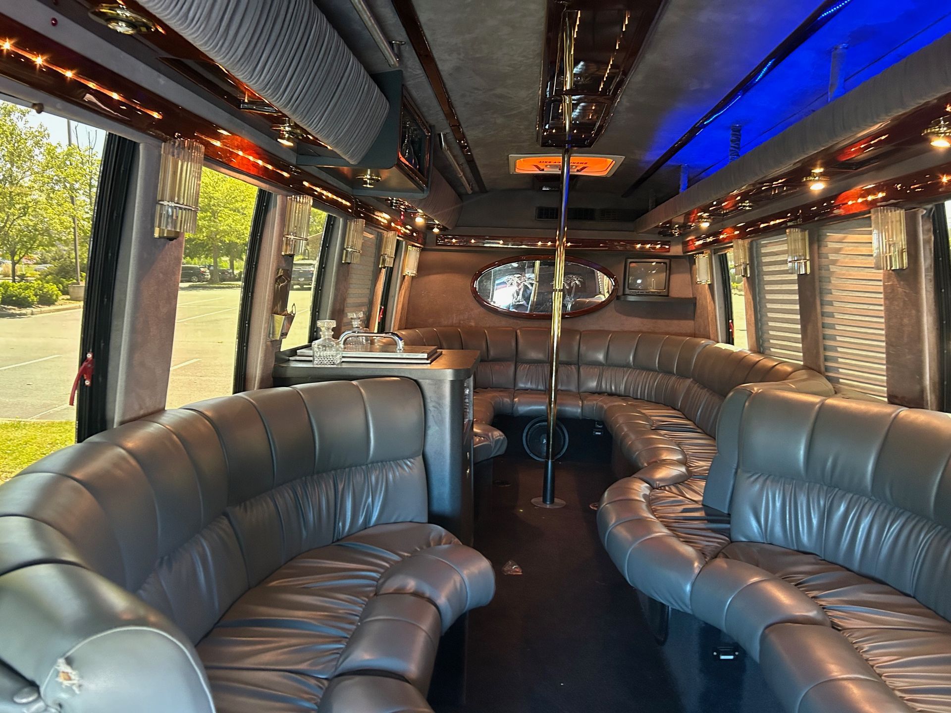 the inside of a limousine with a couch and a pole .