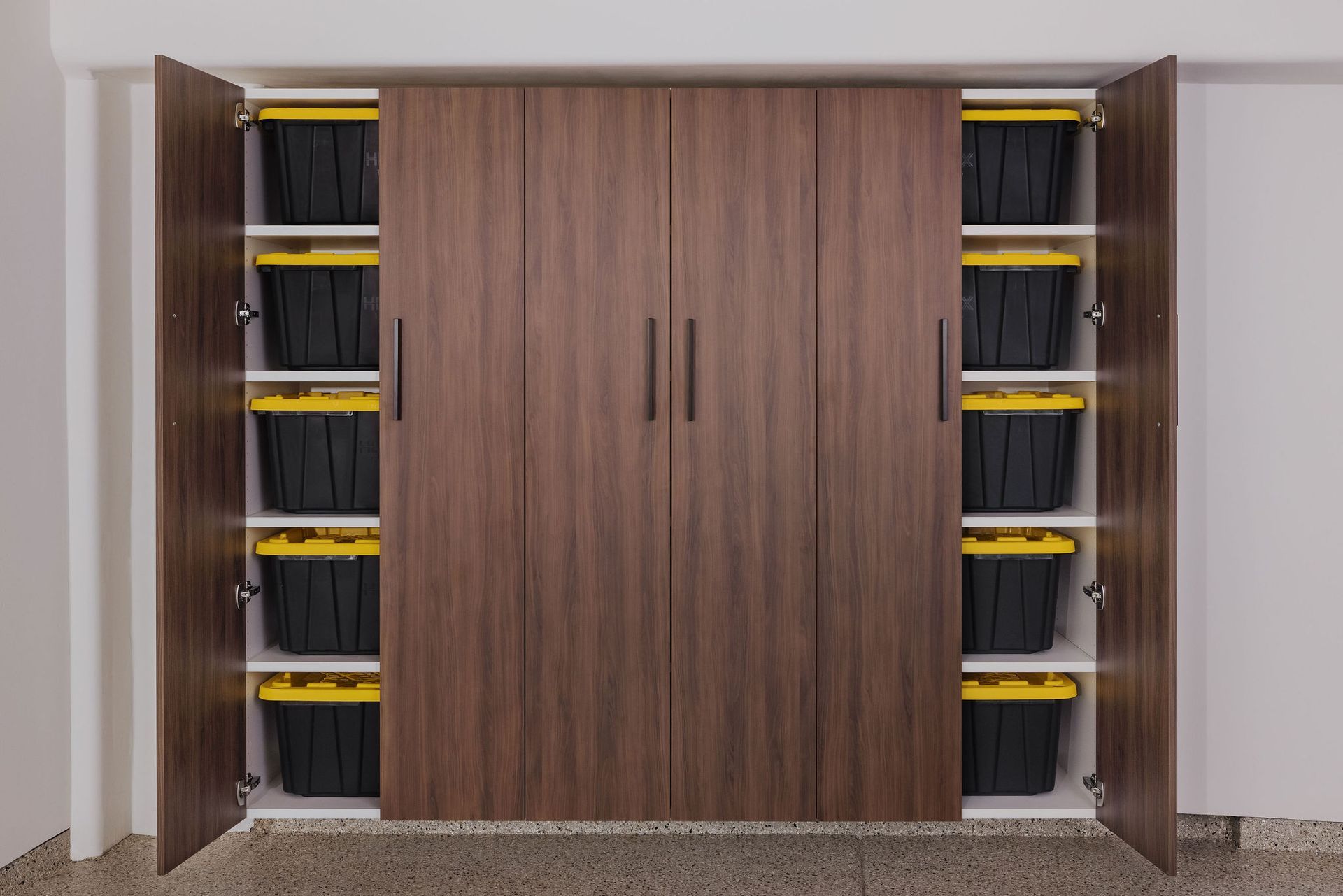 A large wood-finish storage cabinet with closed center doors and open side shelves filled with black bins and yellow lids.