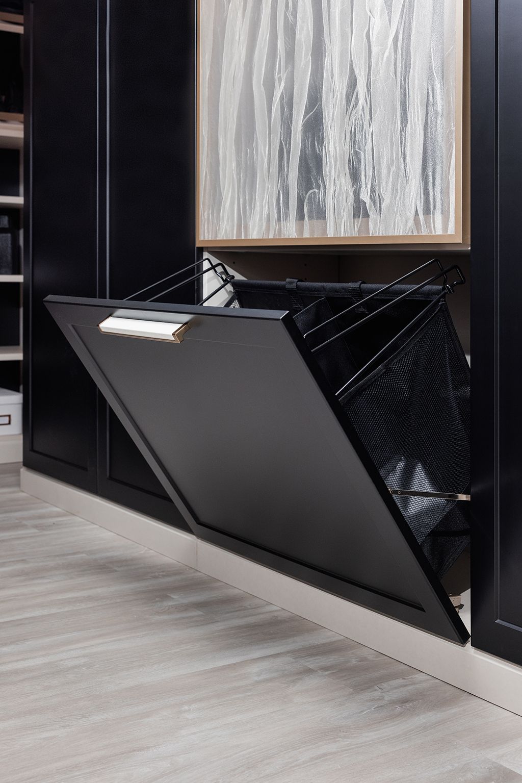 A black laundry basket is open in a closet.