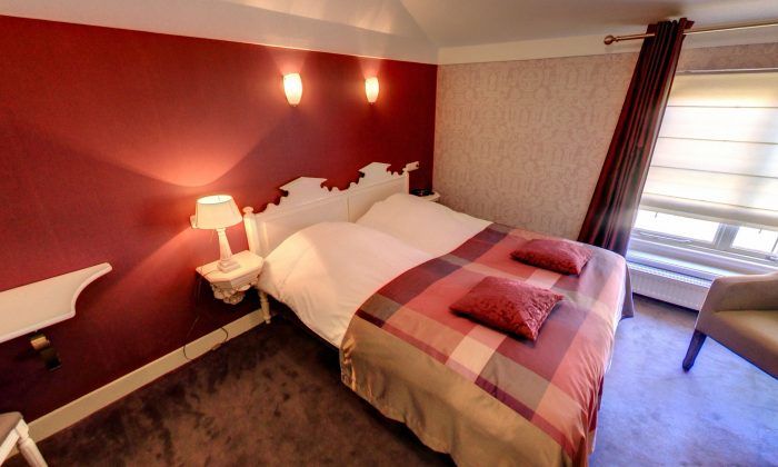 Een hotelkamer met een bed en een stoel