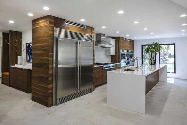A kitchen with stainless steel appliances and a large island.