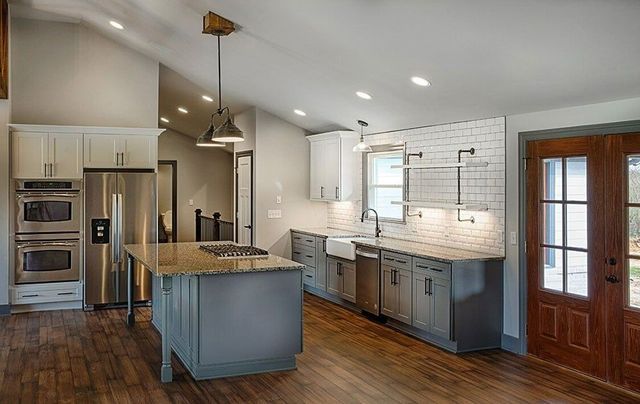 A kitchen with stainless steel appliances , granite counter tops , and a large island.