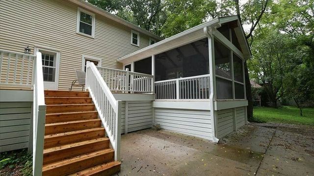 There is a screened in porch with stairs leading up to it.