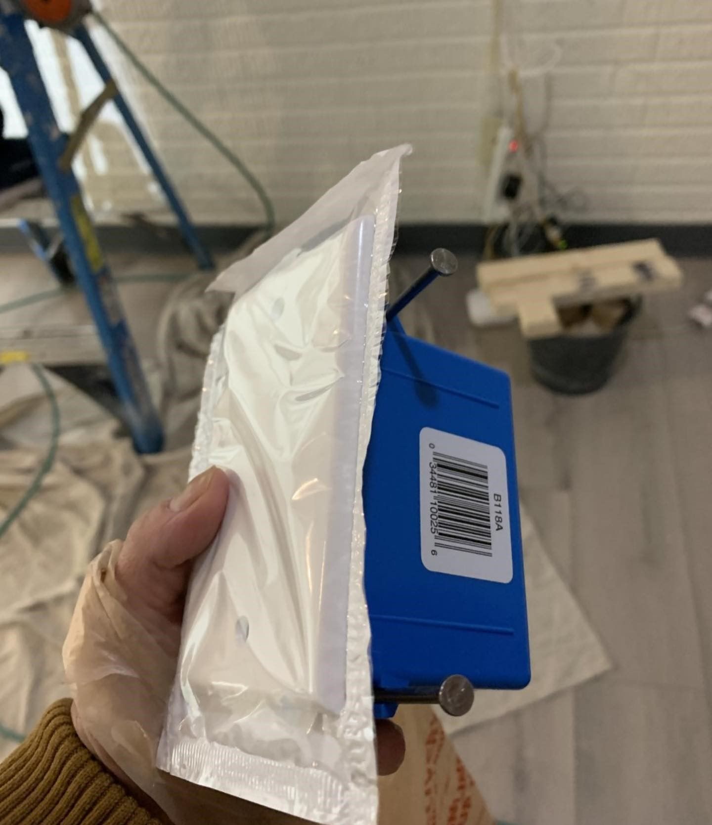 A person is holding a blue box with a barcode on it