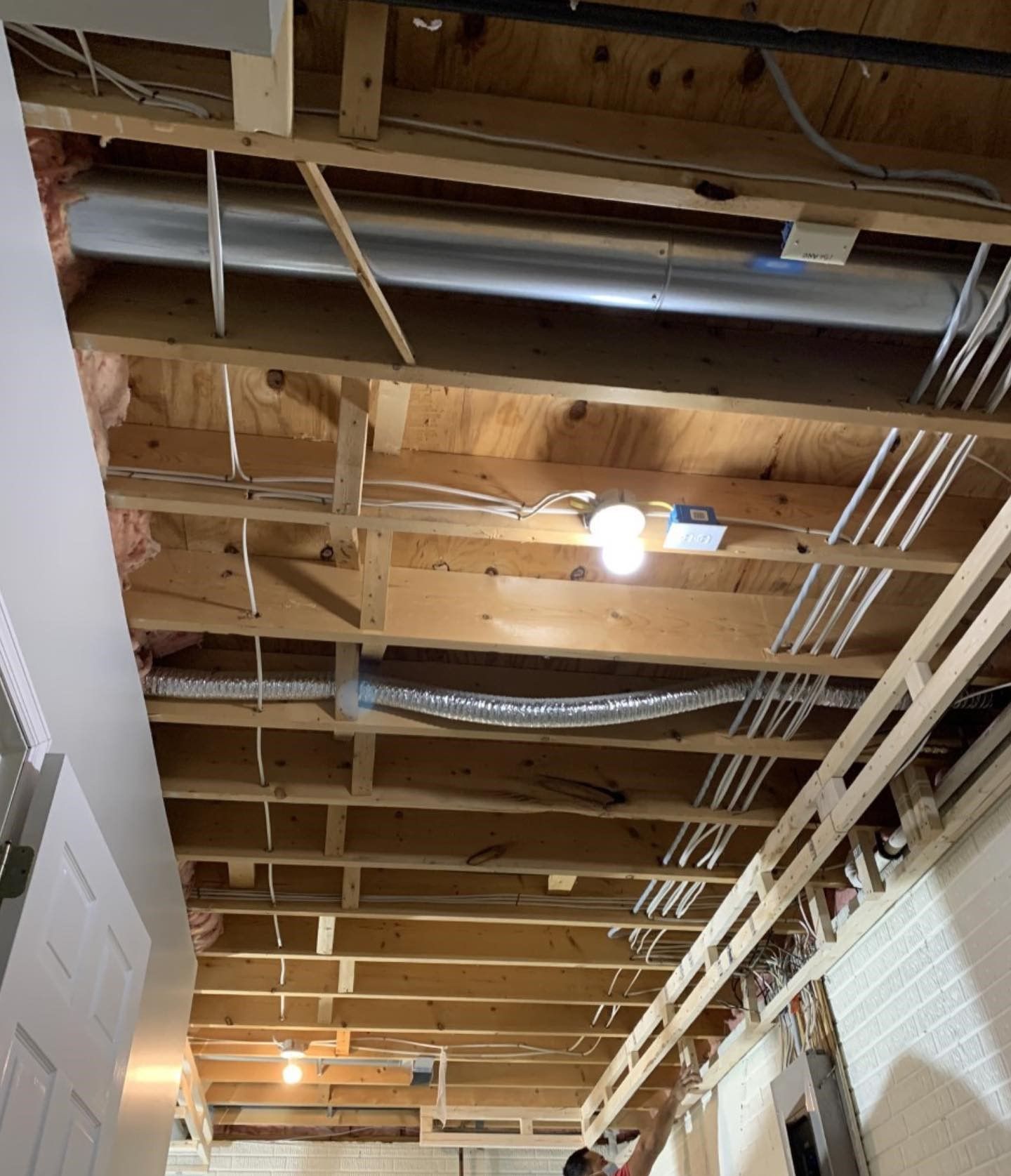 A wooden ceiling with a lot of wires hanging from it.