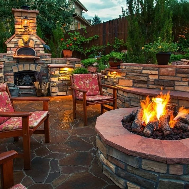 A fire pit surrounded by chairs and a fireplace