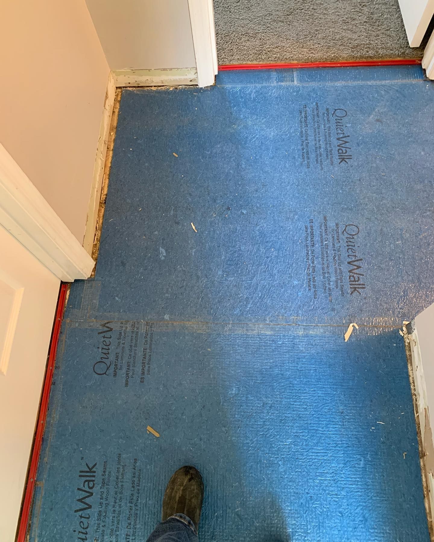 A person standing on a blue carpet that says quick walk on it