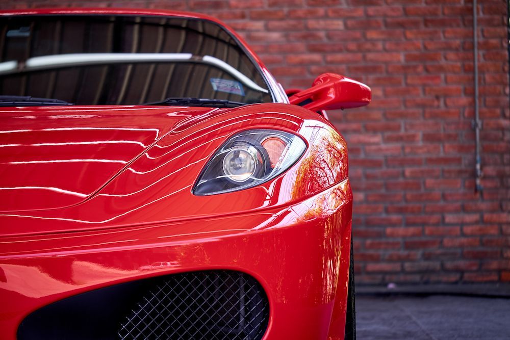 A Red Sports Car is Parked in Front of a Brick Wall — Adettra in Forster, NSW