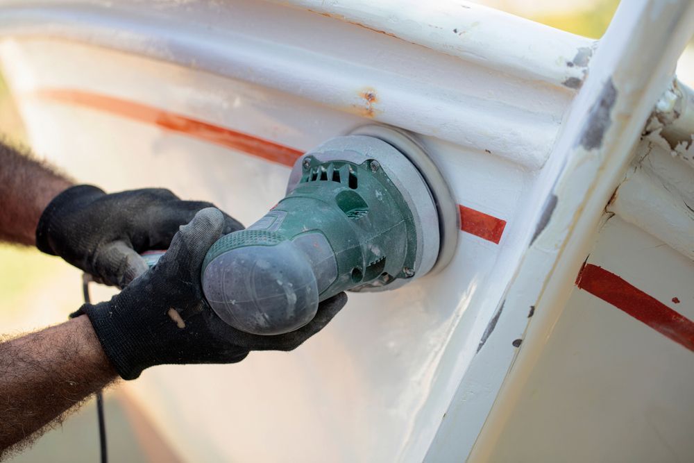 A Person is Sanding a Boat With a Sander — Adettra in Tuncurry, NSW