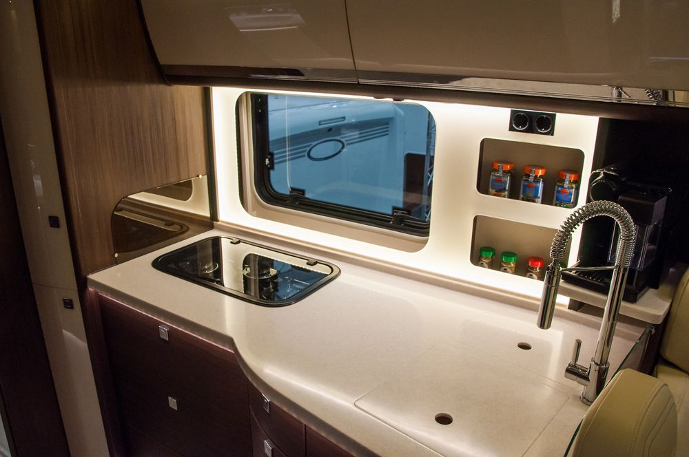 A Kitchen in a Camper Van With a Sink , Stove , and Window — Adettra in Tuncurry, NSW