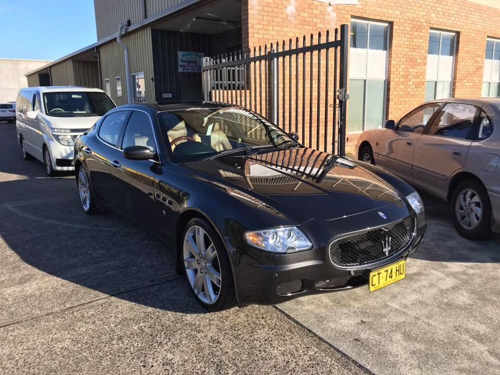 A Black Maserati is Parked in a Parking Lot in Front of a Building  — Adettra in Tuncurry, NSW