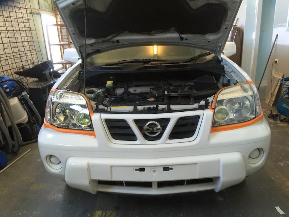 A White Nissan Car With the Hood Open in a Garage — Adettra in Tuncurry, NSW