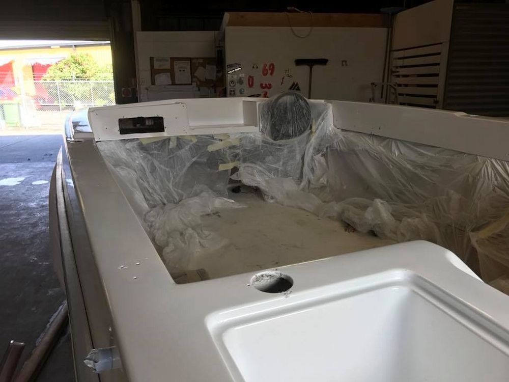 A White Boat is Sitting in a Garage Covered in Plastic — Adettra in Tuncurry, NSW