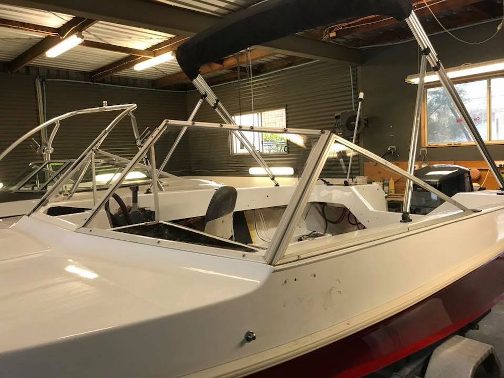 A White Boat With a Black Canopy is Sitting in a Warehouse — Adettra in Tuncurry, NSW