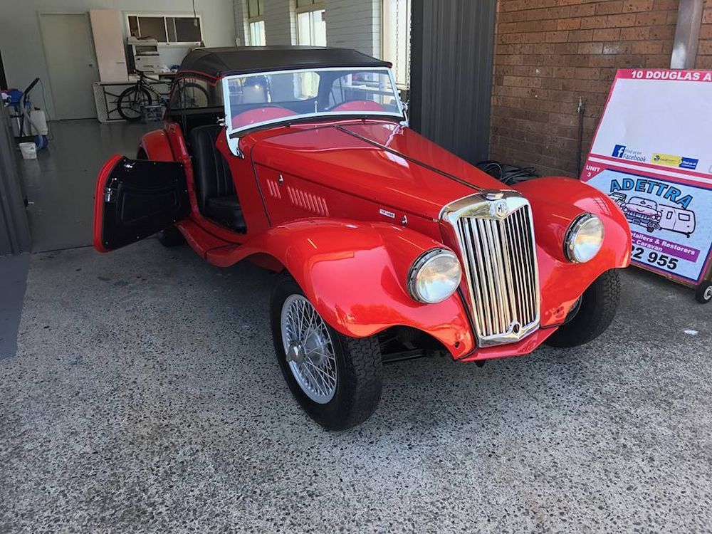 A Red Vintage Car is Parked in Front of a Building — Adettra in Tuncurry, NSW
