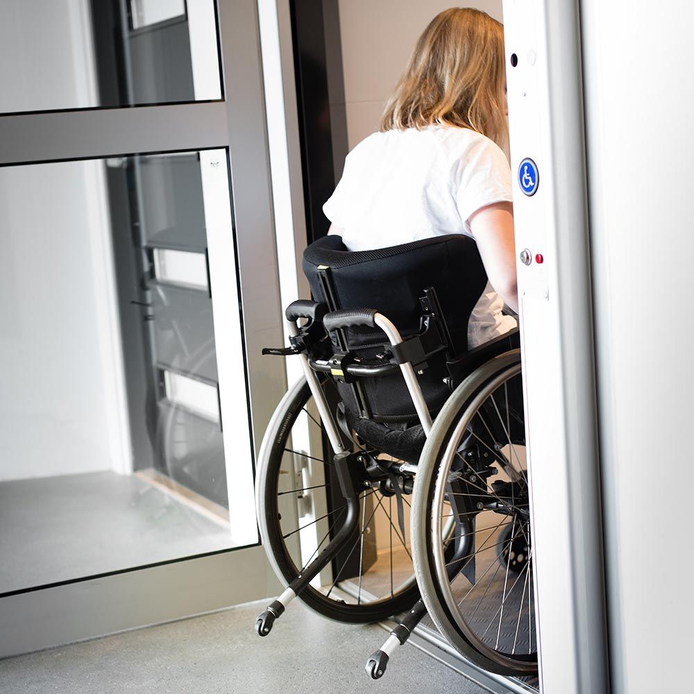 Wheelchair user entering an accessible elevator with mobility friendly design.