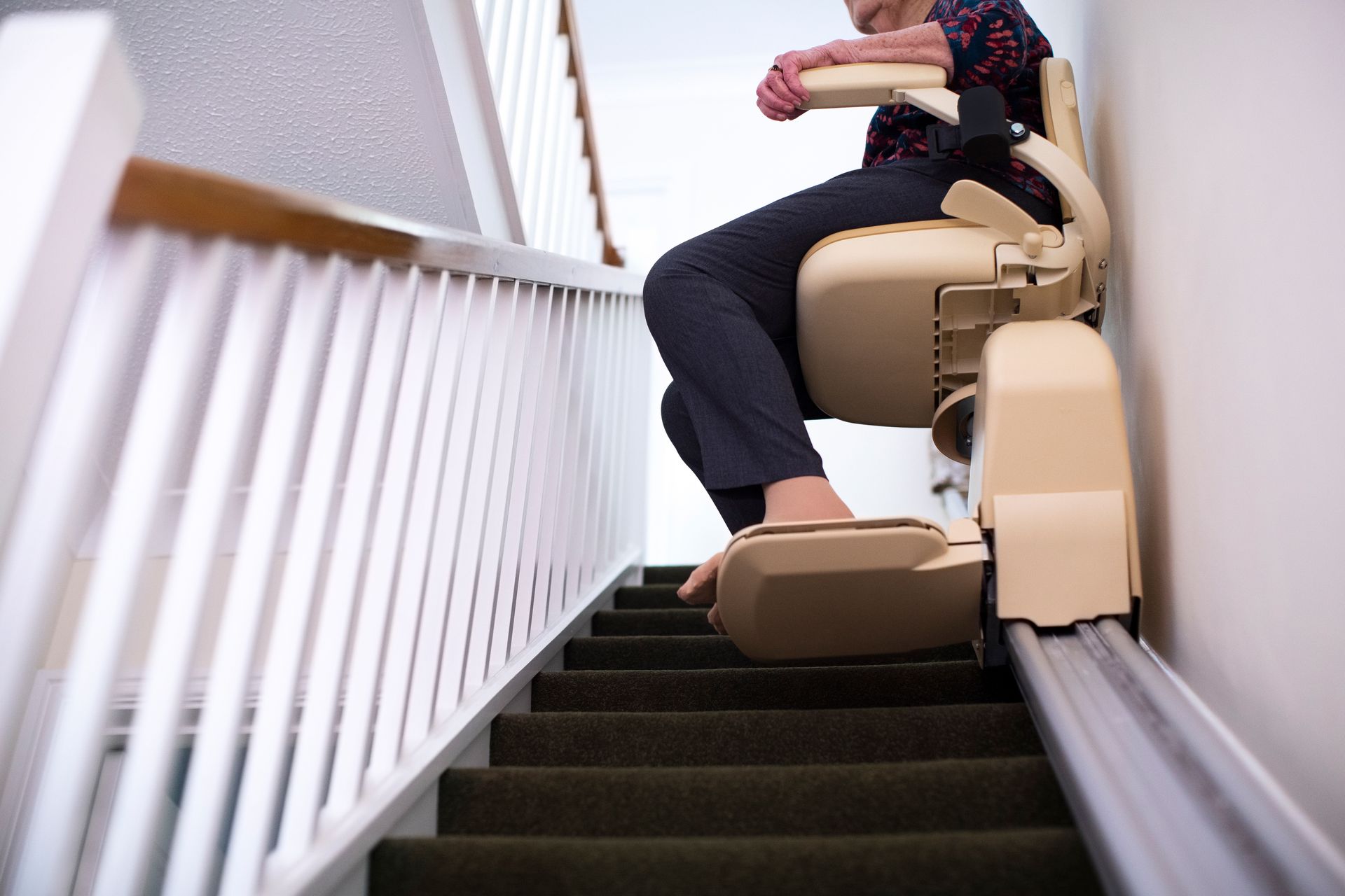 A woman sitting on a stair lift.