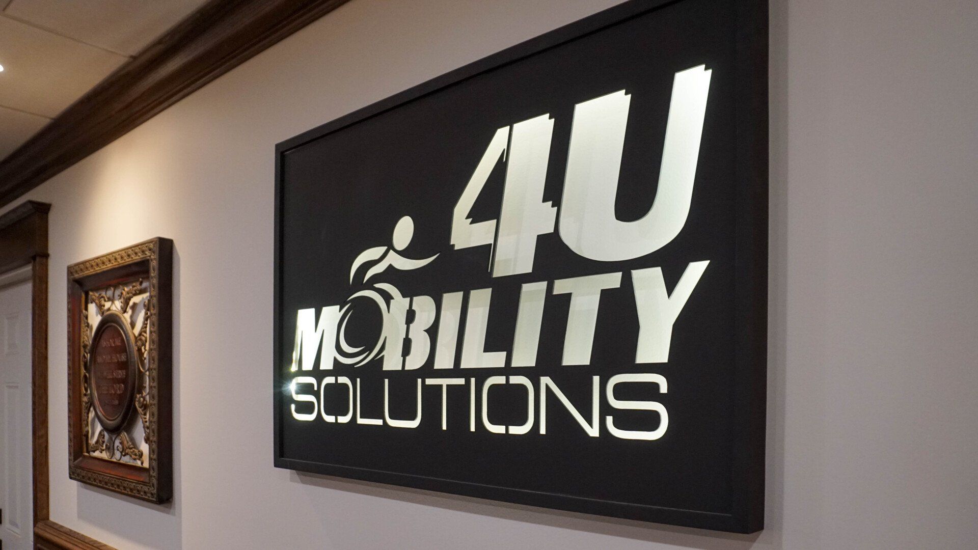 A sign for 4u mobility solutions hangs on a wall