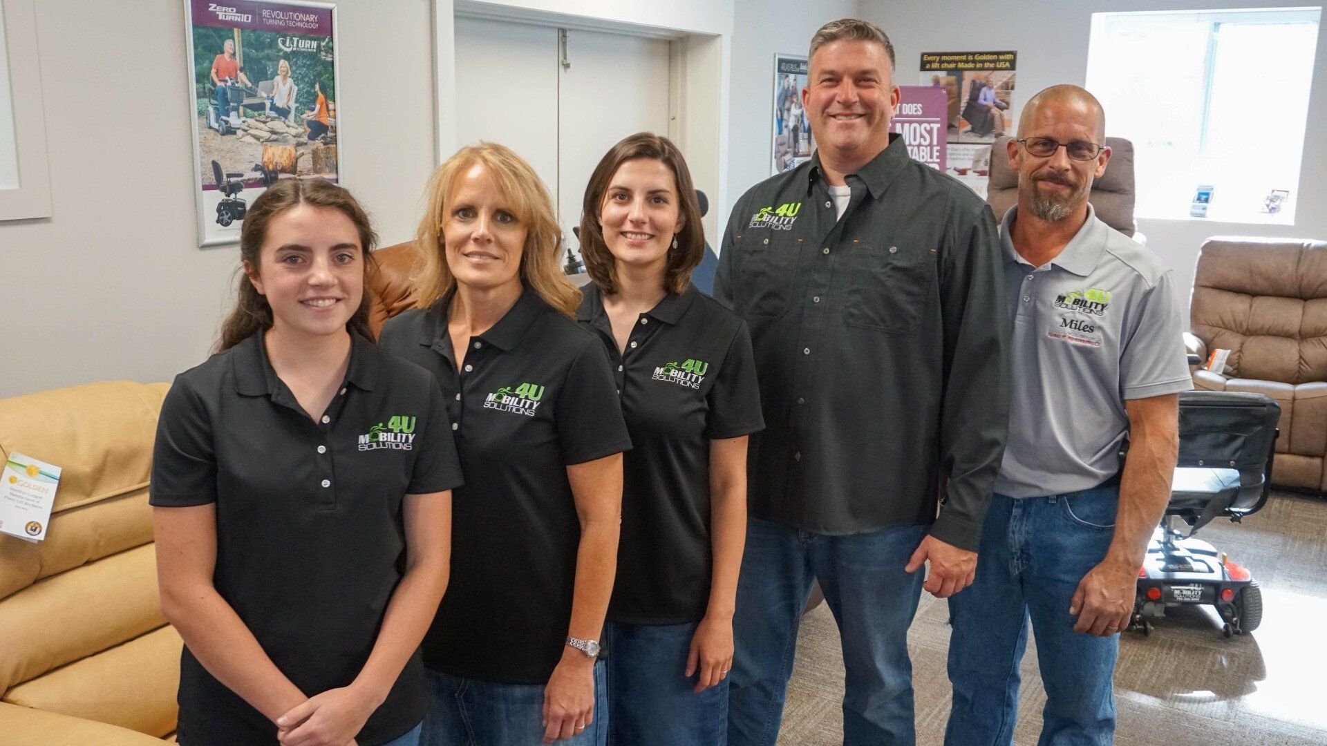 A group of people are posing for a picture in a living room.