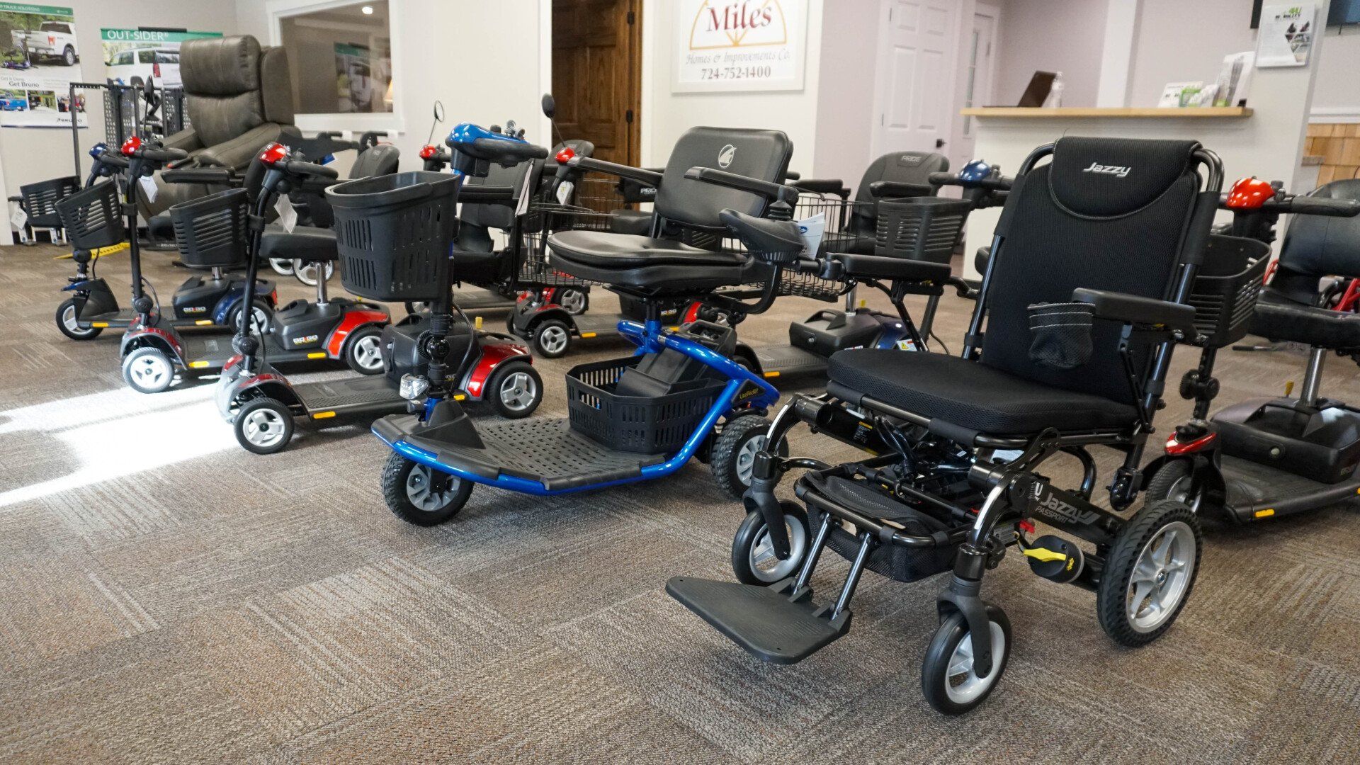 A row of electric wheelchairs and scooters in a store.