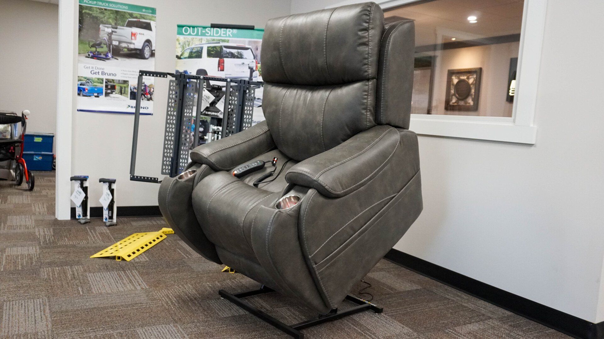 A gray recliner is sitting in a room next to a window.