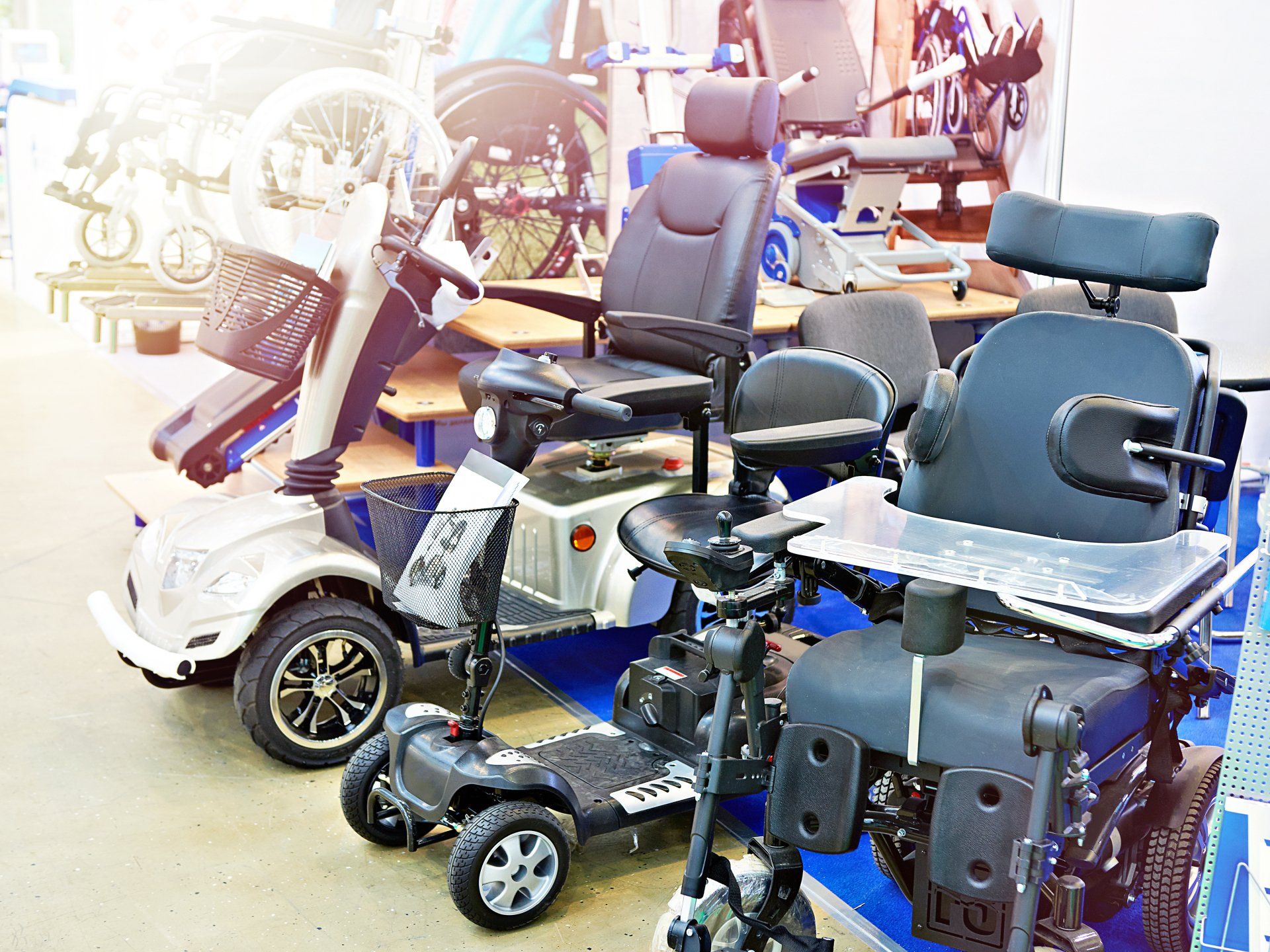 A row of electric wheelchairs are lined up in a room.