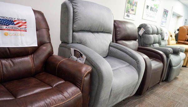 A row of recliner chairs are lined up in a store.