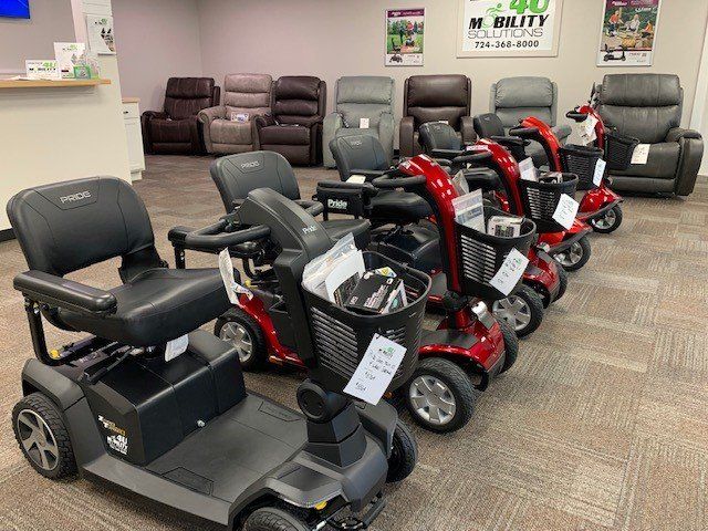 A row of mobility scooters are lined up in a store.