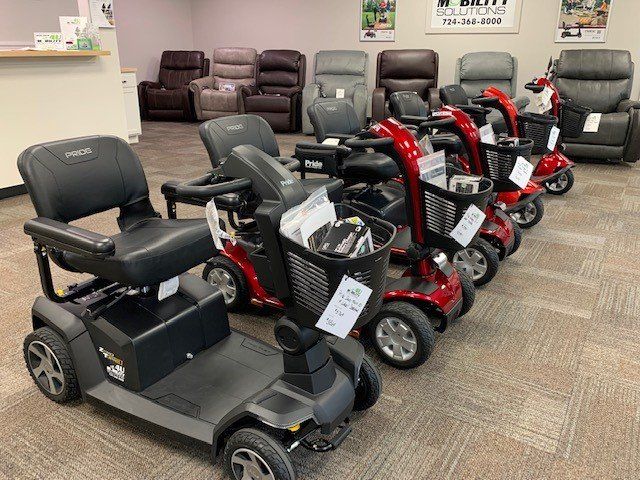 A row of mobility scooters are lined up in a store.