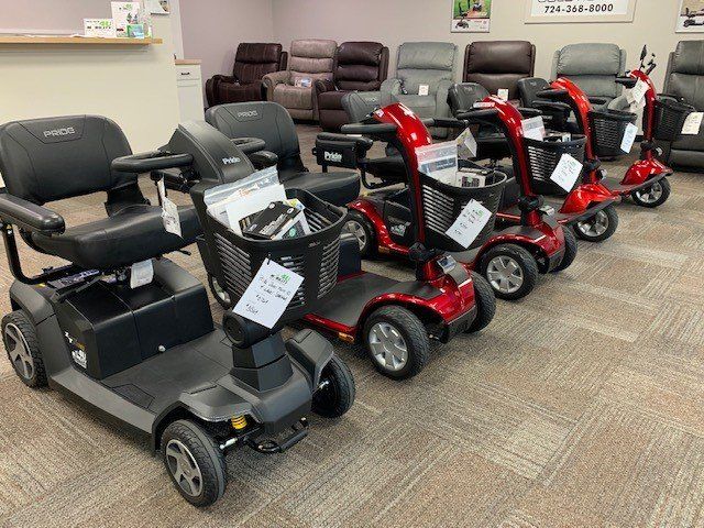 A row of mobility scooters are lined up in a showroom.