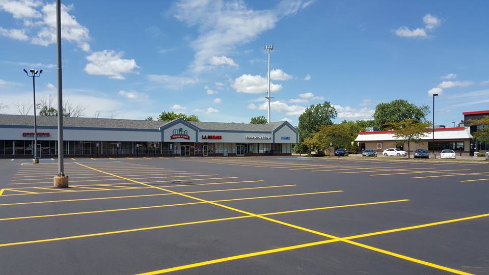 Front Of Store With Newly Sealcoat Parking Lot With Few Cars - Clio, MI - Chippewa Asphalt Paving